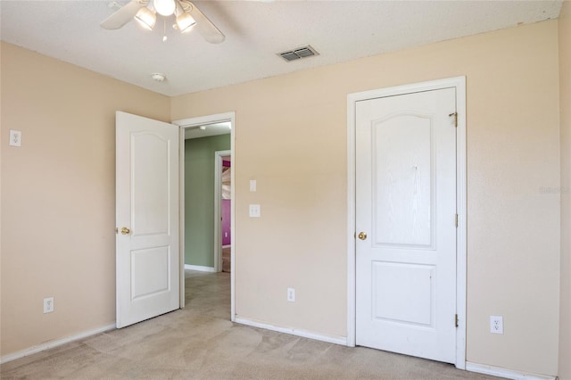 unfurnished bedroom with baseboards, light carpet, visible vents, and a ceiling fan