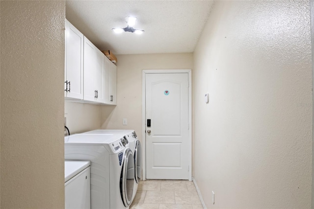 laundry area featuring separate washer and dryer, cabinet space, baseboards, and light tile patterned flooring