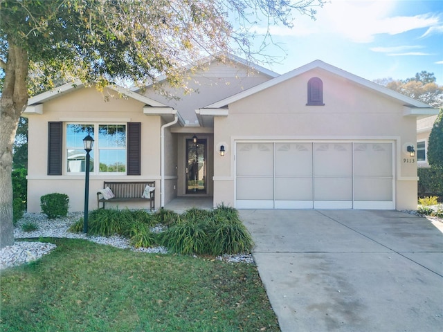 single story home with stucco siding, a front lawn, concrete driveway, and a garage