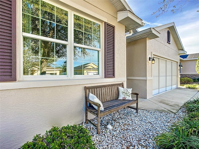 property entrance featuring an attached garage and stucco siding