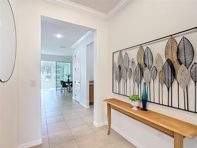 hall with light tile patterned floors, baseboards, and crown molding