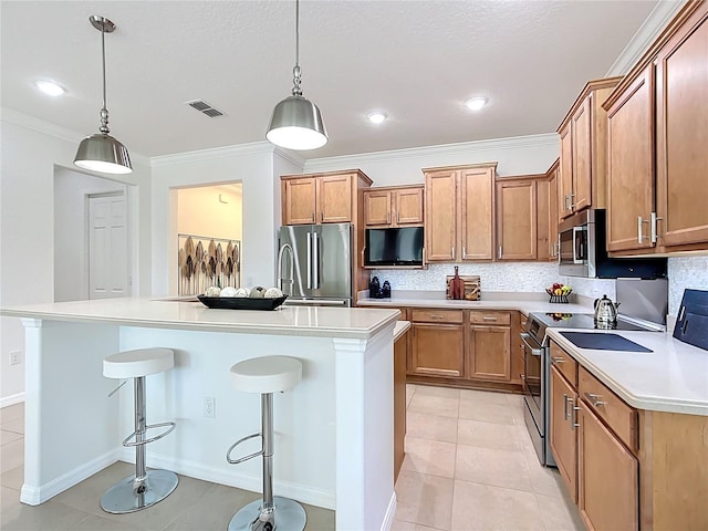 kitchen featuring a breakfast bar, light countertops, backsplash, and stainless steel appliances