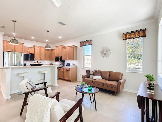 living area featuring baseboards, visible vents, and ornamental molding