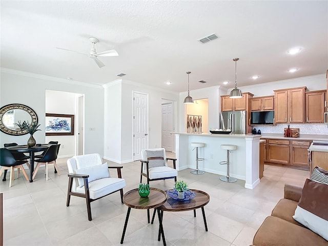 living room with crown molding, baseboards, visible vents, and ceiling fan