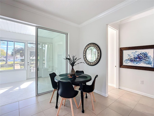 dining space featuring light tile patterned floors, baseboards, and ornamental molding