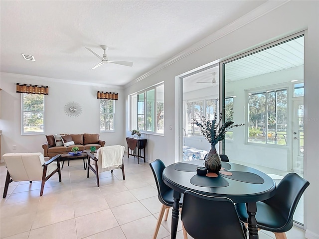 dining area with crown molding, light tile patterned flooring, a healthy amount of sunlight, and visible vents