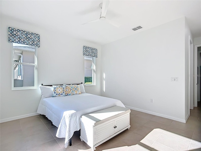 bedroom with tile patterned floors, visible vents, a ceiling fan, and baseboards