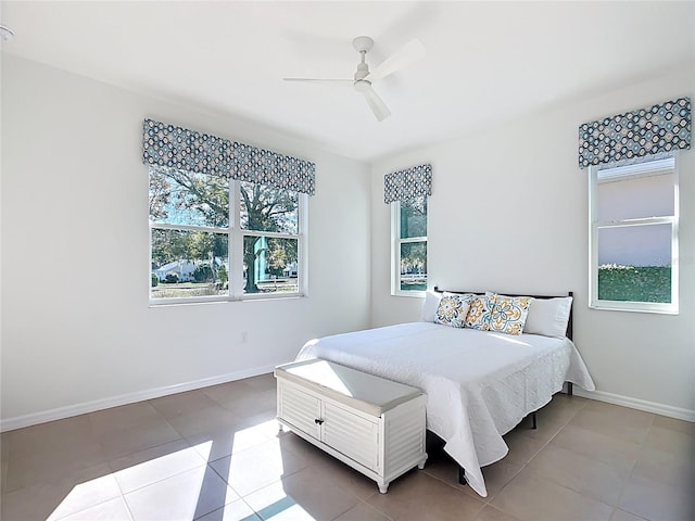 bedroom featuring tile patterned floors, a ceiling fan, and baseboards