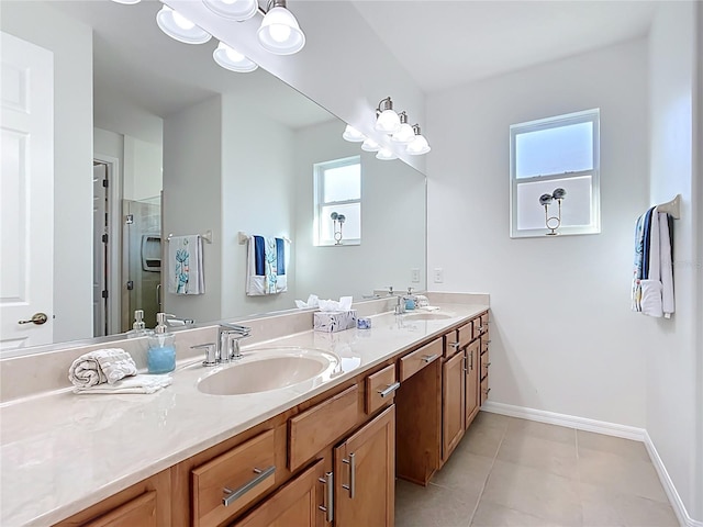 full bath with baseboards, double vanity, a stall shower, a sink, and tile patterned floors