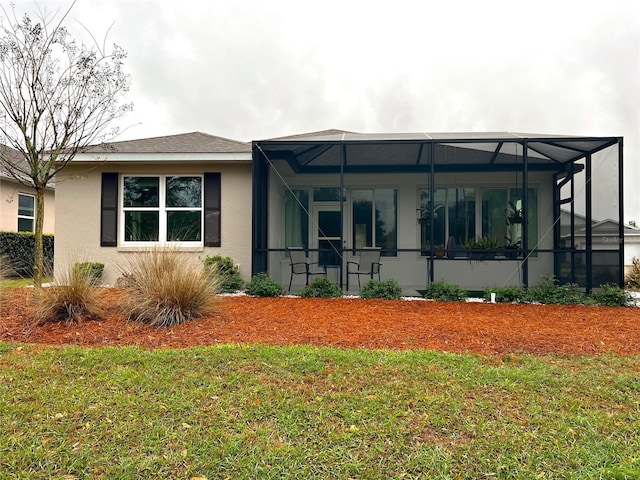 view of front of property featuring a lanai, a front yard, and stucco siding