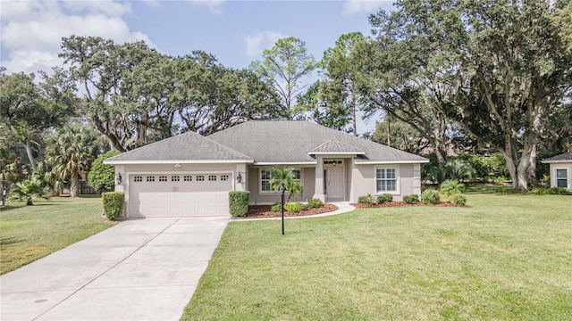 single story home with stucco siding, a front yard, an attached garage, and driveway