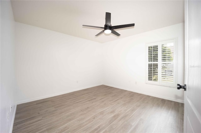 spare room featuring ceiling fan, baseboards, and wood finished floors