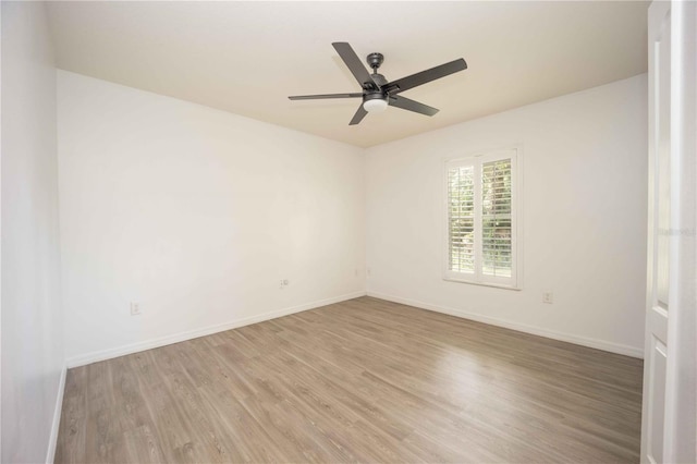 spare room featuring ceiling fan, light wood-type flooring, and baseboards