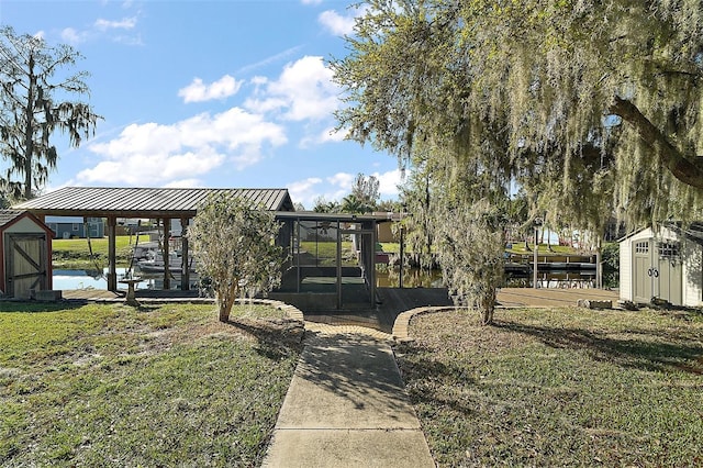 view of yard featuring an outdoor structure, a water view, and a shed