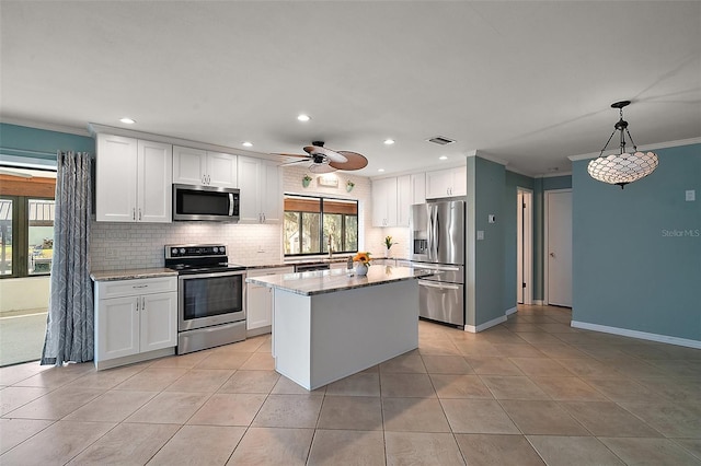 kitchen featuring visible vents, stainless steel appliances, white cabinets, crown molding, and backsplash