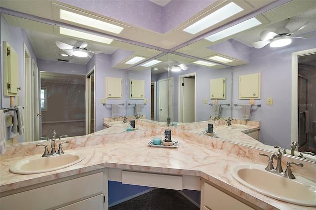 bathroom featuring a sink, a skylight, and ceiling fan