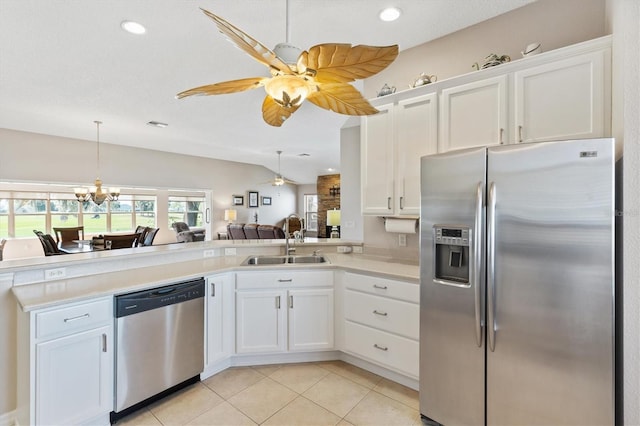 kitchen featuring light countertops, appliances with stainless steel finishes, light tile patterned flooring, white cabinetry, and a sink