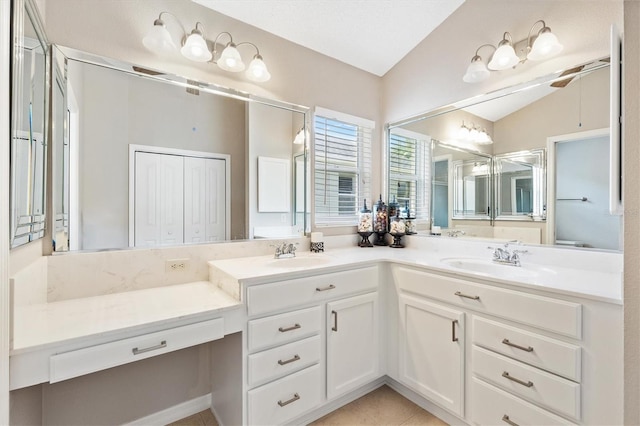 bathroom featuring double vanity, tile patterned flooring, lofted ceiling, and a sink