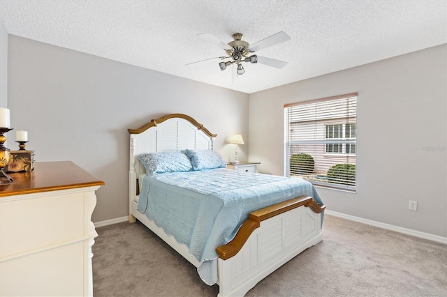 bedroom with baseboards, light carpet, a textured ceiling, and ceiling fan