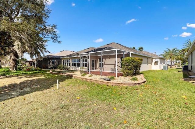 back of property featuring a lanai, a patio area, central AC, and a yard