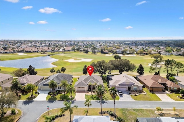 drone / aerial view with a residential view, view of golf course, and a water view