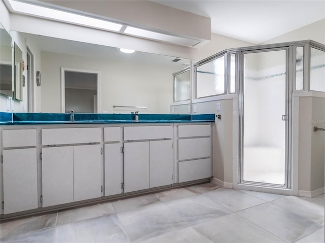 bathroom with a wealth of natural light, a stall shower, double vanity, and a sink