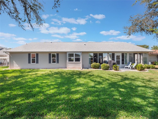 rear view of house with a patio, a yard, and a sunroom