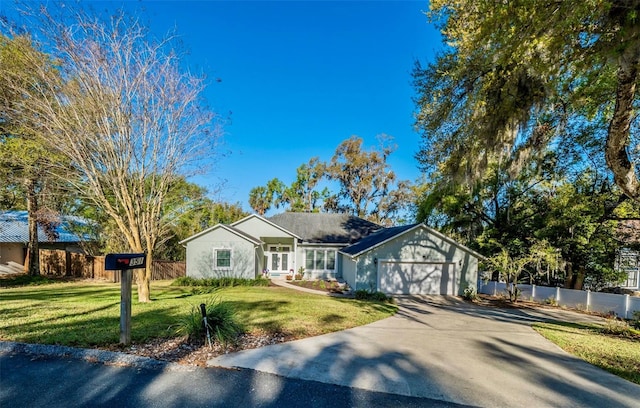 ranch-style house with a front yard, fence, a garage, and driveway