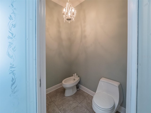 bathroom with tile patterned flooring, baseboards, toilet, a bidet, and an inviting chandelier