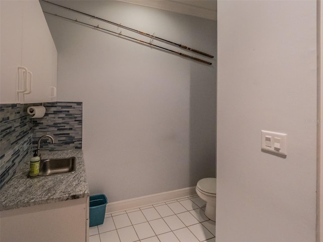 bathroom with tile patterned floors, toilet, tasteful backsplash, baseboards, and vanity