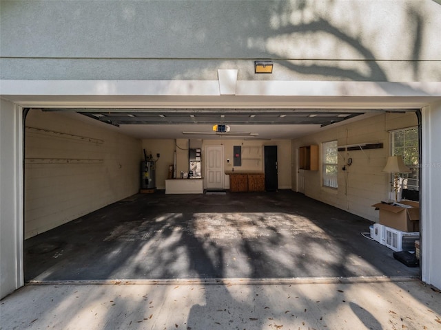 garage with electric panel, a garage door opener, and water heater