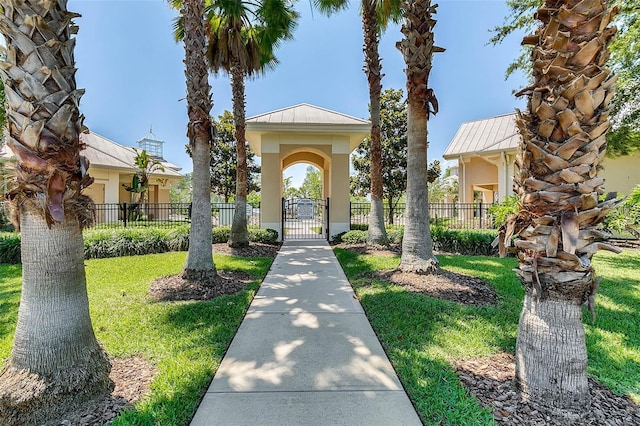 view of property's community featuring a fenced front yard, a lawn, and a gate