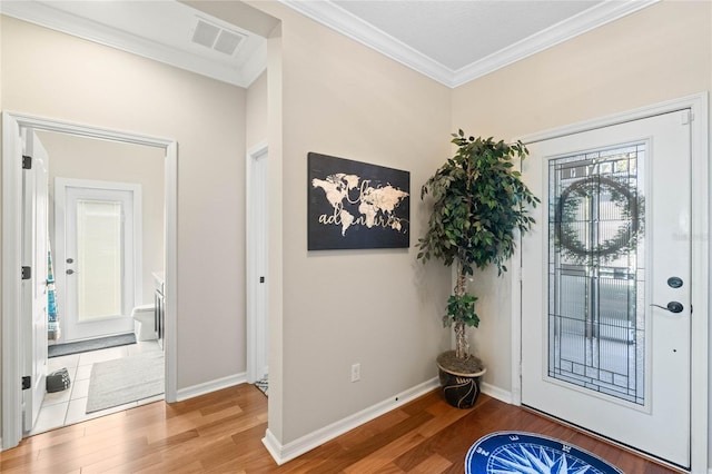 entryway with visible vents, ornamental molding, baseboards, and wood finished floors