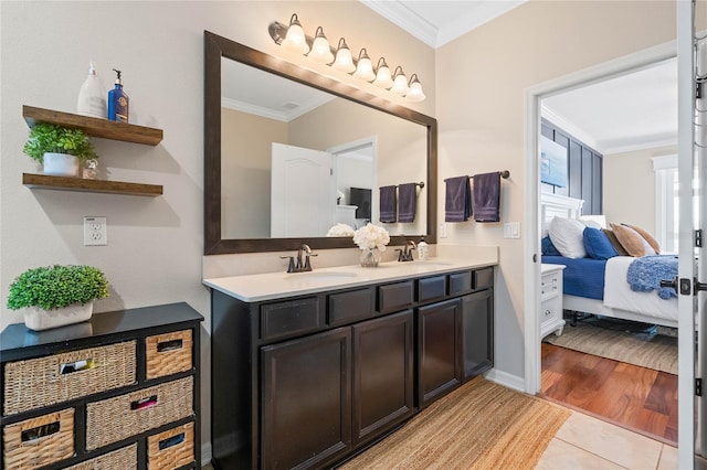 ensuite bathroom with double vanity, ornamental molding, ensuite bathroom, and a sink