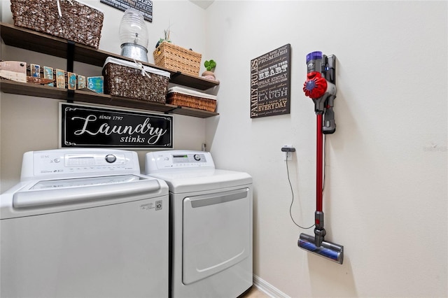 clothes washing area with laundry area, baseboards, and independent washer and dryer