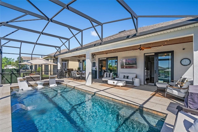 pool featuring an outdoor living space, glass enclosure, a patio, and a ceiling fan