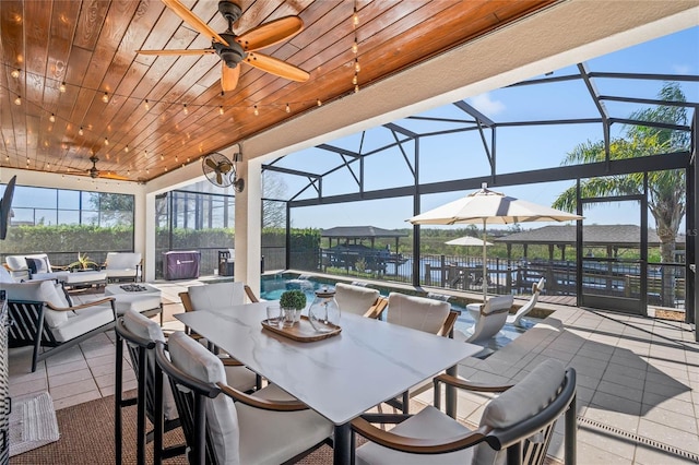 view of patio / terrace featuring ceiling fan, glass enclosure, an outdoor pool, and outdoor dining space