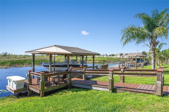 dock area featuring a water view, boat lift, and a lawn