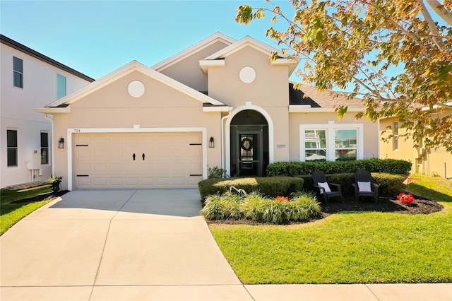 mediterranean / spanish-style house featuring stucco siding, a front yard, concrete driveway, and an attached garage