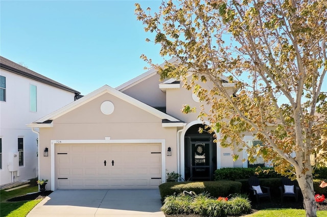 view of front facade featuring stucco siding, driveway, and a garage