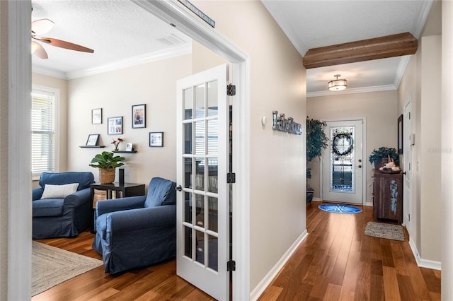 entryway featuring ornamental molding, baseboards, and wood finished floors