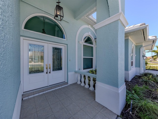 view of exterior entry featuring french doors and stucco siding