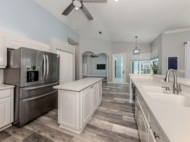 kitchen with arched walkways, a ceiling fan, stainless steel refrigerator with ice dispenser, and a sink