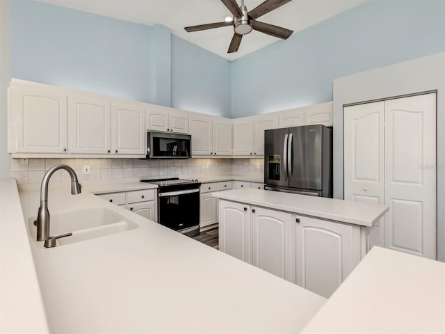 kitchen featuring a ceiling fan, a sink, backsplash, appliances with stainless steel finishes, and light countertops