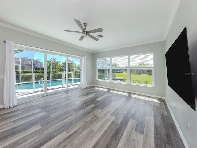 unfurnished living room featuring visible vents, baseboards, ornamental molding, wood finished floors, and a ceiling fan