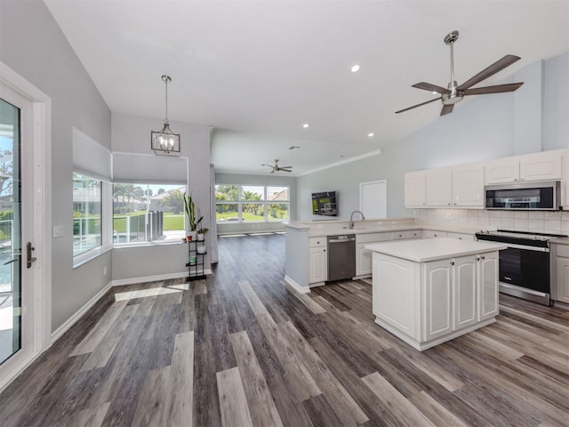 kitchen with open floor plan, stainless steel appliances, white cabinets, light countertops, and decorative backsplash