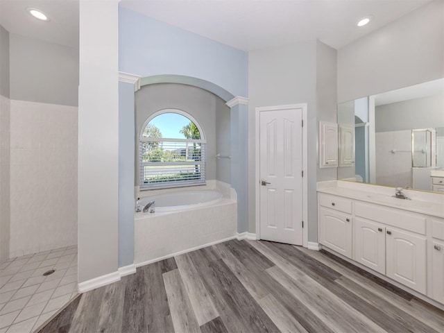 full bathroom featuring vanity, wood finished floors, recessed lighting, a walk in shower, and a bath