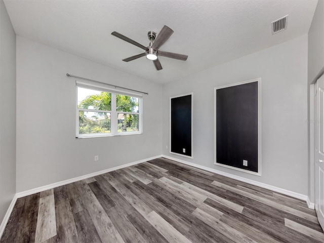 unfurnished bedroom featuring a ceiling fan, wood finished floors, visible vents, and baseboards