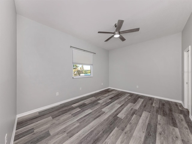 unfurnished room with ceiling fan, baseboards, and wood finished floors