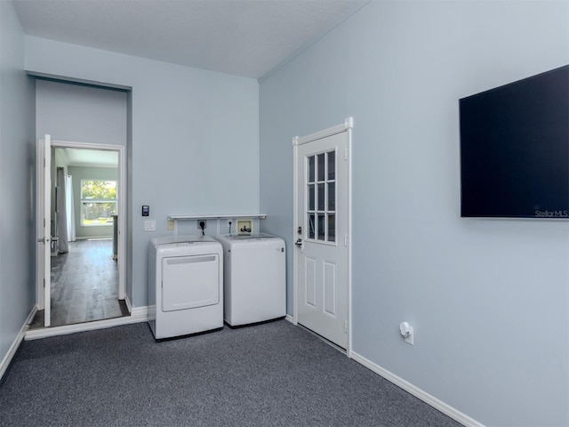 clothes washing area featuring washer and clothes dryer, laundry area, dark carpet, and baseboards